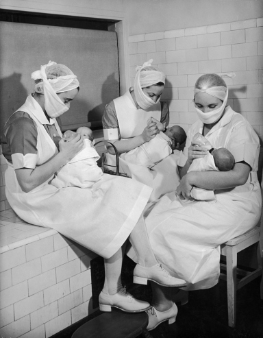 Hansel Mieth - The LIFE Picture Collection/Getty Images/Caption from LIFE. "Fully developed, the premature babies drink from regular bottles containing either mother's milk or formula milk. Nurses always wear masks over mouth and nose."